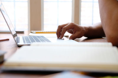 Midsection of woman using laptop on table