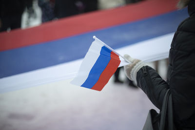 Flag of russia in hand. symbol of state of russian federation. national flag.