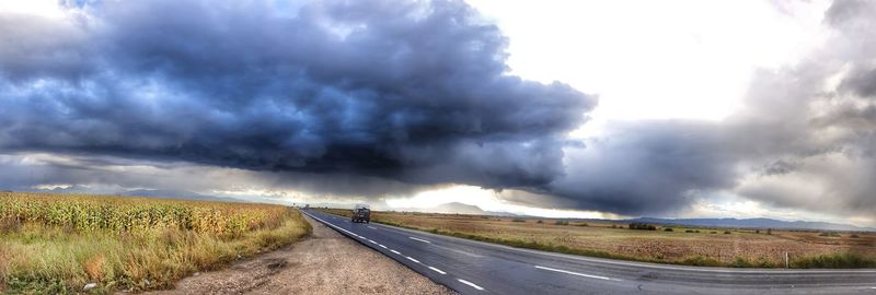 Panoramic view of storm clouds over road