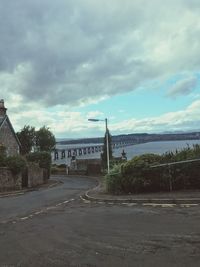 View of bridge over road against cloudy sky