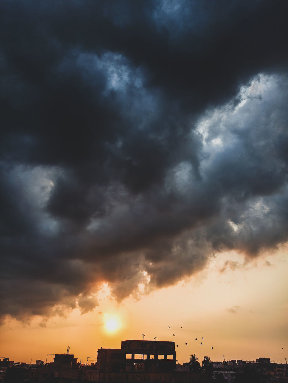 SILHOUETTE BUILDINGS AGAINST DRAMATIC SKY