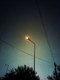 Low angle view of silhouette street light against sky