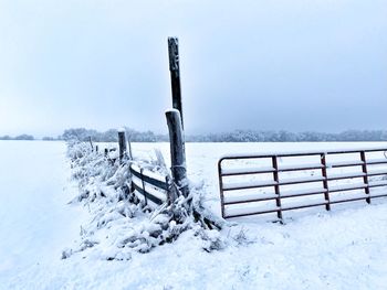 Scenic view of snow covered field against sky