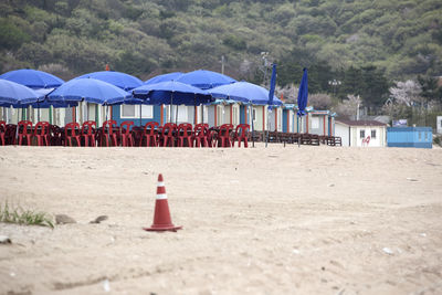 Row of beach huts, umbrellas, and dining chairs