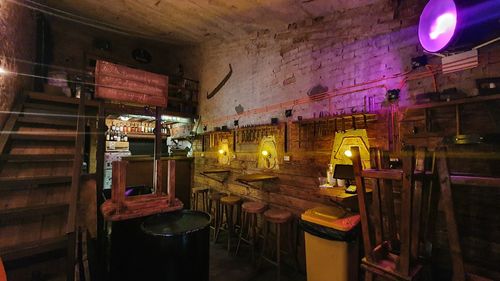 High angle view of illuminated lighting equipment on table against wall at night