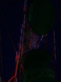 Low angle view of illuminated ferris wheel against sky at night