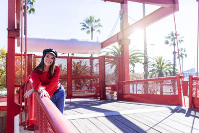 Smiling teenage girl wearing red top in city during sunny day