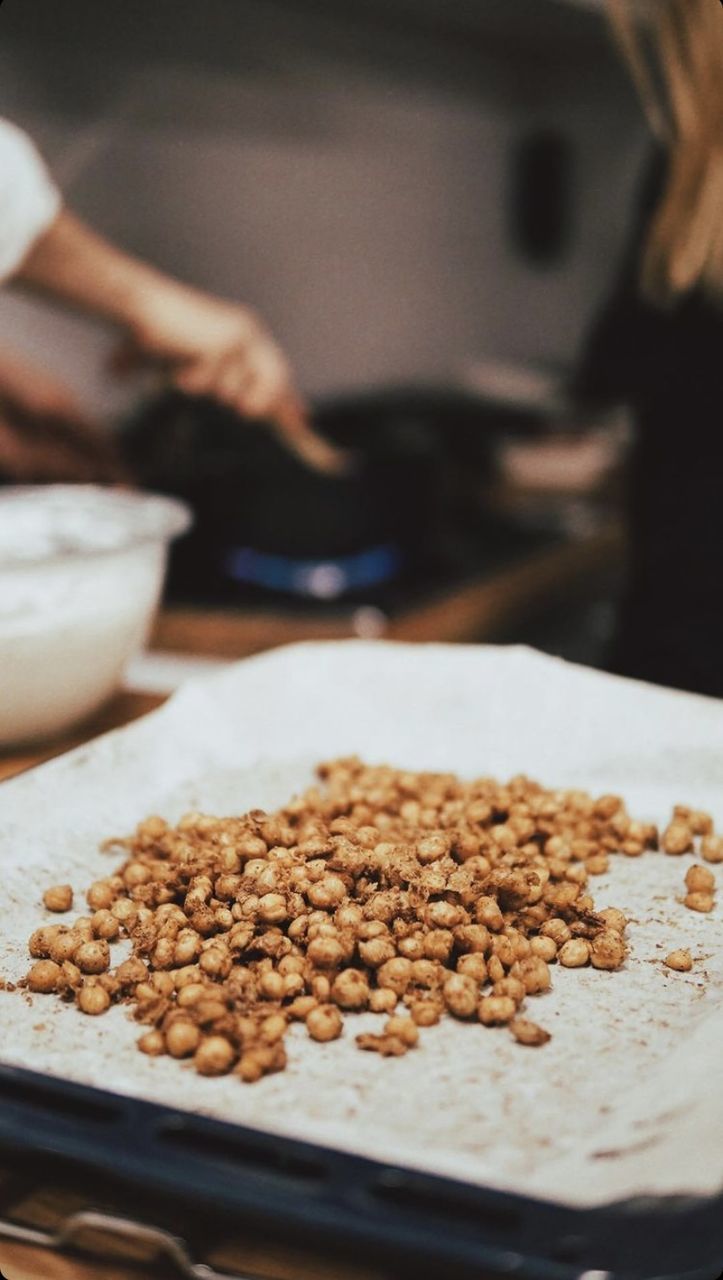 CLOSE-UP OF PERSON PREPARING BREAD IN KITCHEN