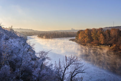 Steamy river flowing through a wintry landscape at dawn