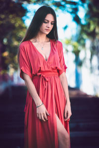 Beautiful young woman standing against red umbrella