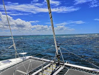 Sailboat sailing on sea against blue sky