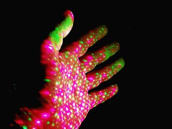 Close-up of illuminated hand over black background