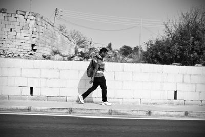 Rear view of woman walking against built structure