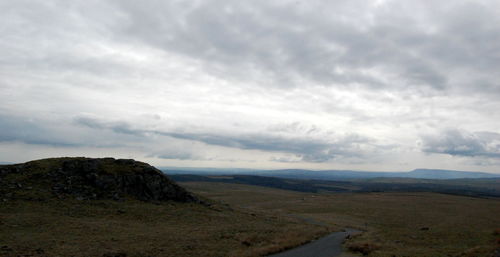 Scenic view of road leading towards mountains against sky