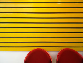 Red chairs against yellow wall