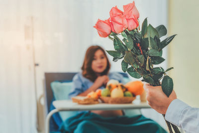 Midsection of woman sitting on table at home