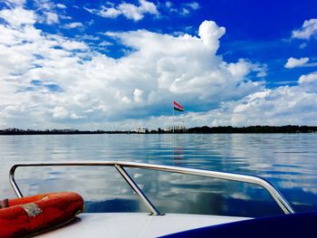 Cropped image of boat sailing in sea against cloudy sky