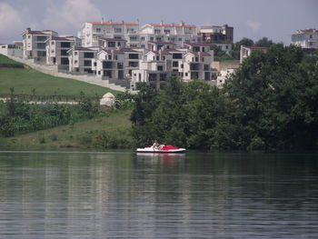 Scenic view of lake by buildings against sky