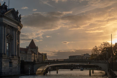 Bridge over river against cloudy sky