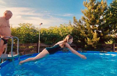 Girl jumping in swimming pool