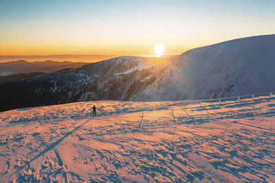 Scenic view of snow covered mountains against sky during sunset