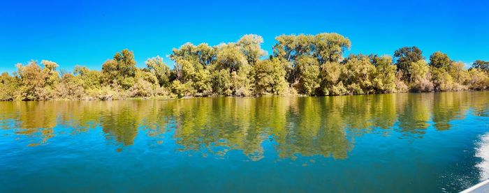 Scenic view of lake against clear blue sky
