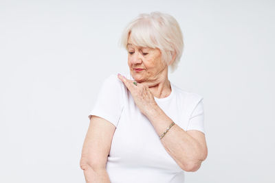 Portrait of young woman standing against white background