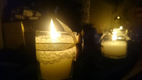 Close-up of illuminated candle on table