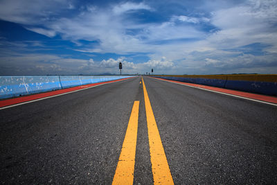 Empty road against cloudy sky