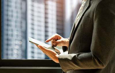Midsection of man using mobile phone