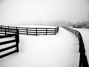 Staircase on snow covered landscape against clear sky