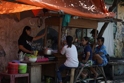 People sitting at market stall