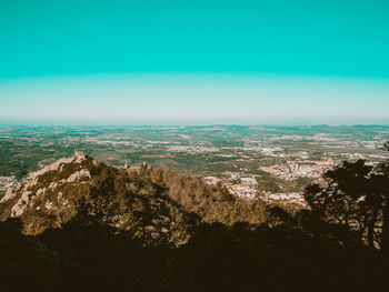 Aerial view of sea and cityscape against clear sky