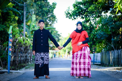 Full length of couple holding hands standing outdoors