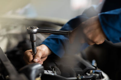 Close-up of man working on bicycle