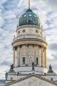 Low angle view of german cathedral against cloudy sky at gendarmenmarkt, berlin, germany