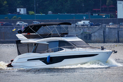 A speedboat cuts through the river waters against the backdrop of the city's stone embankment.