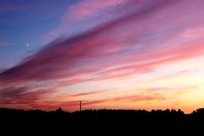 Scenic view of silhouette landscape against orange sky
