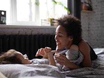 Smiling young woman relaxing on bed