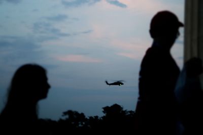 Low angle view of silhouette people against sky at sunset