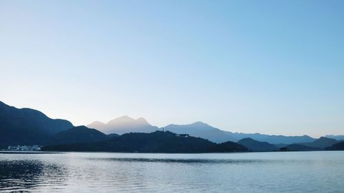 Scenic view of lake and mountains against clear sky