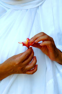 Midsection of nun holding flower