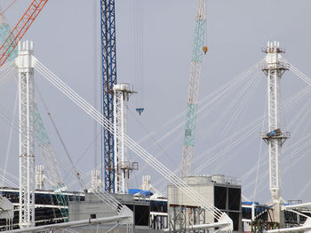 Low angle view of cranes against sky