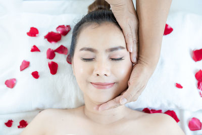 Portrait of young woman lying down on bed