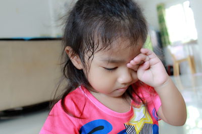 Close-up of baby girl sitting on floor at home