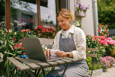 Young woman using laptop while sitting on table