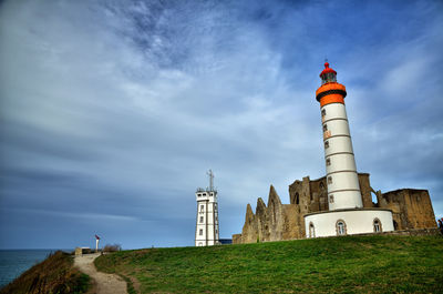 Low angle view of lighthouse on field against sky