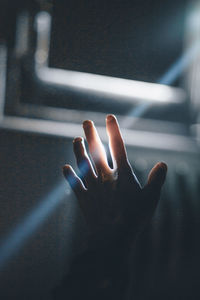 Close-up of hand touching illuminated light