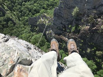 Low section of man on rock by trees