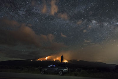 Cars on street against sky at night